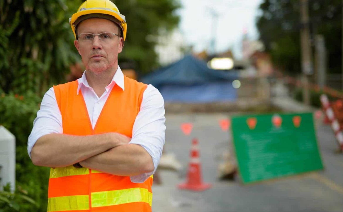 Mature man construction worker at the construction site in the c