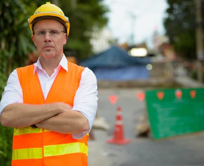 Mature man construction worker at the construction site in the c